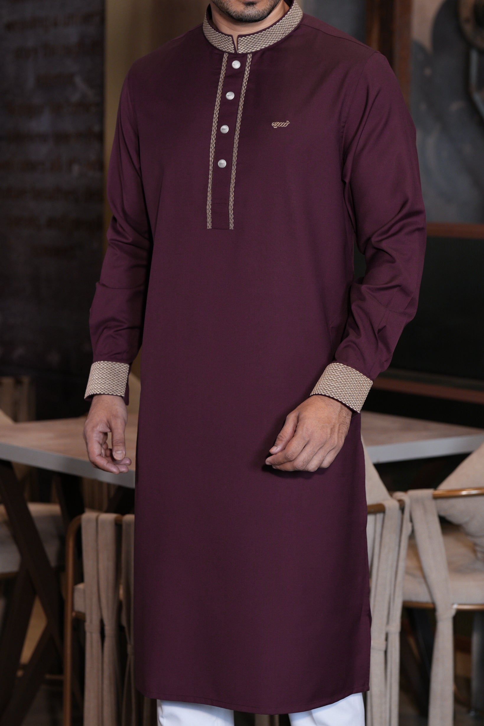 Man wearing a maroon long-sleeve shirt with beige accents in an indoor setting.