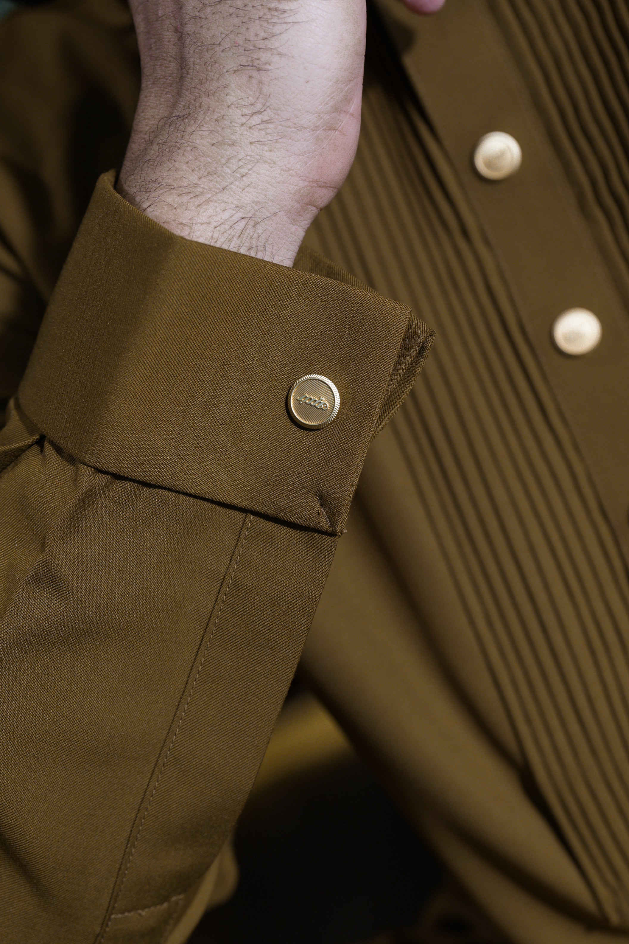 Close-up of a brown jacket with a button and collar detail